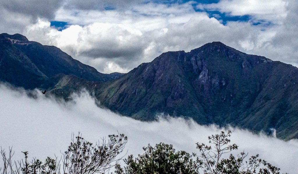 Peruvian Andes peek up through fog and reach toward clouds, 2015, T. M. Adair